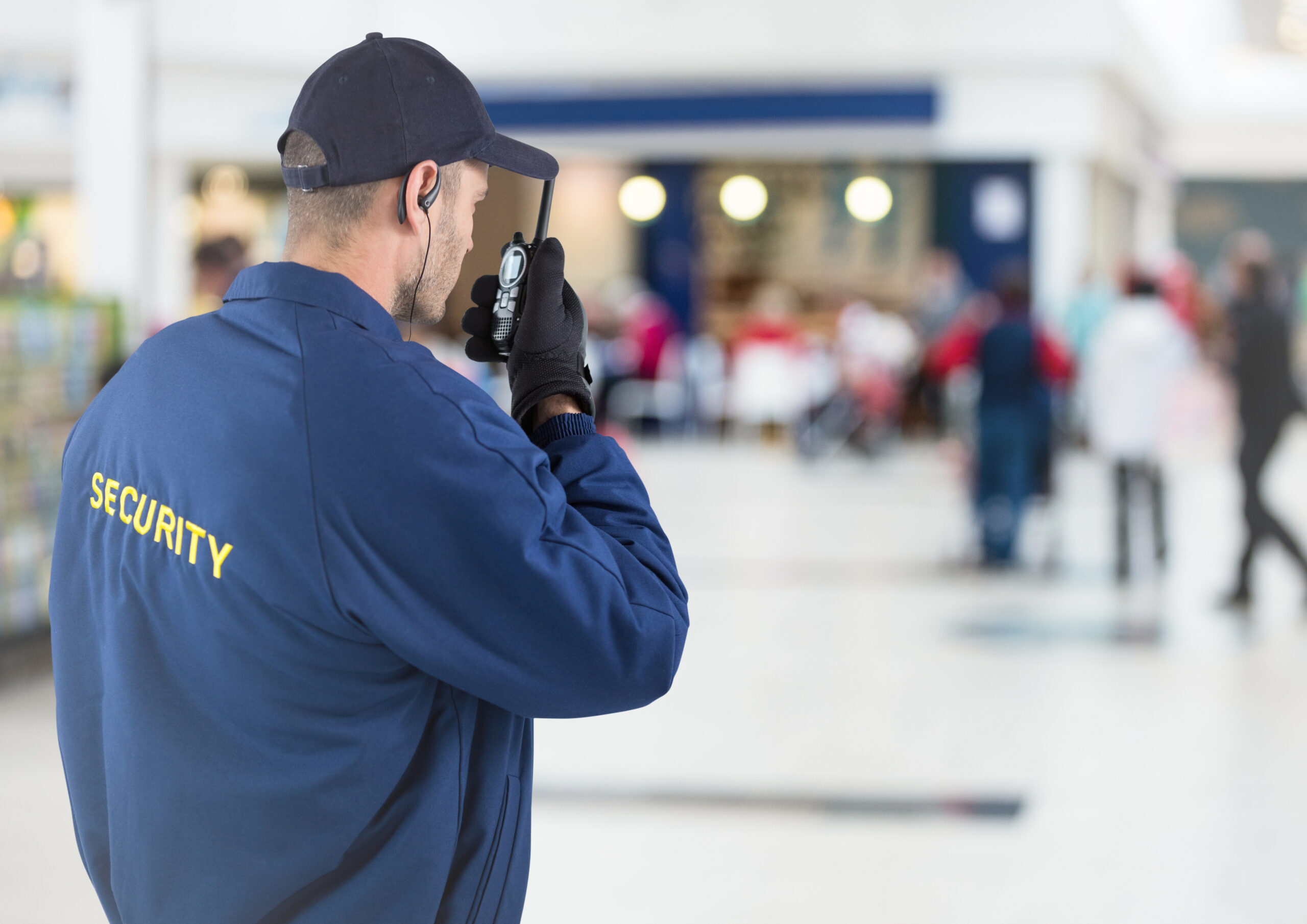 Security guard standing at business entrance providing retail security.